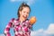 Kid hold ripe apple sunny day. Kid girl with long hair eat apple blue sky background. Healthy nutrition concept. Child