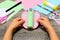 Kid holding colored paper butterfly in hands. Little kid shows a fun paper diy