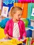 Kid holding colored paper on table in kindergarten .