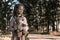 Kid holding dirty teddy bear near trees in chernobyl, post apocalyptic concept