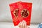 Kid holding pair of red pockets translation of the Chinese in English:fortune