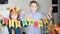 Kid holding paper garland with text Give thanks. Children decorating living room for celebrating Thanksgiving day.