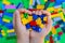 A kid holding small pieces of interlocking plastic colorful bricks toy