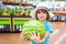 Kid holding watermelon in supermarket. Vegetables in store.