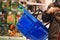 Kid holds shopping basket over blurred background of store. Shopping, sales and discounts