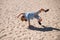 Kid jumping upside down on sand. Lifestyle portrait of funny kid outdoors. Summer kids outdoor portrait. Close up face