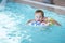 Kid learns to swim using a plastic water ring