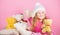 Kid little girl play with soft toy teddy bear pink background. Softness is key. Child small girl playful hold teddy bear