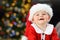 Kid looking at camera in christmas wearing santa disguise