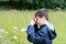 Kid looking through mini microscope with wondering face, Excited Child on a camping school trip in green forest, Kid explorer with