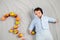 The kid is lying with apples. A newborn boy was lying with apples. Little baby in white bodysuit on gray. Top view, flat lay