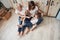 Kid lying on the parent`s legs. Mother, grandmother and daughter having good time in the kitchen