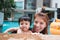 The kid and mom play together in the pool