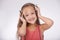 Kid, music and portrait of girl with headphones in studio for audio, subscription and streaming multimedia on white