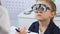 Kid in optical trial frame looking doctor prescribing eyeglasses, ophthalmology