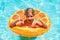 Kid with orange in the pool. Summer fruits. Kids summer vacation. Children floating in water pool. Children playing and