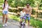 Kid with patents learning to ride bicycle in park