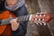 Kid playing acoustic guitar close-up.