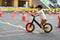 Kid playing balance bike in racetrack, speed motion