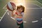 Kid playing basketball. Child boy preparing for basket ball shooting. Best sport for kids. Active kids lifestyle.