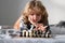 Kid playing chess. Child thinking near chessboard. Learning and growing children, childgood. Chess game with children at