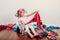 Kid playing with clothes on head. Cute Caucasian girl sorting clothes. Adorable funny child arranging organazing clothing. Messy