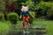 Kid playing out in the rain. Children with umbrella and rain boots play outdoors in heavy rain. Little boy jumping in muddy puddle