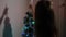 Kid plays for Christmas holidays. small child plays by Christmas tree in childrens room. daughter examines garland on