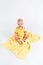 Kid on the plush yellow blanket on the white background