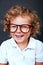 Kid portrait in eyeglasses smiling over black backgrund