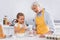 Kid pouring flour near smiling granny