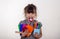 Kid ready for school. Cute clever child in eyeglasses holding school supplies: pens, notebooks, scissors, alarm clock and apple.