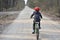 Kid with red helmet cycling in the woods