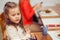 Kid in  restaurant. Spoiled child in restaurant in front of plate with sushi and cup of water smiling looking to side does not