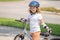 Kid riding on sporty bicycle in summer park. Child in safety helmet riding bike. Boy riding bike outside. Child in