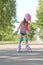 Kid on roller skates in full sports gear is standing on sidewalk trying to make first move.