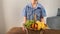 Kid rolls in his hands a basket of fruits and vegetables on a wooden table, concept of a children`s game in the store, shopping