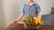 Kid rolls in his hands a basket of fruits and vegetables on a wooden table, concept of a children`s game in the store, shopping