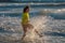 Kid running into sea water during summer holidays. Kid boy running along ocean. Child on summer beach. Child run a race