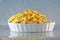 Kid`s favorite macaroni and cheese  in a fancy white dish of on a multicolor soft bokeh background