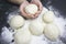 Kid`s hands, some flour an wheat dough on the black table. Children hands making the rye dough for backing bread or pizza. Small