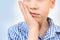 Kid, a schoolboy holds his hand on the lower jaw, wrinkles from toothache, the concept of pediatric dentistry, treatment of milk