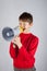 Kid shouting in megaphone on bright background