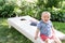 Kid sitting on Cornhole board in backyard on fourth of July