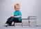 Kid sitting on a a steps made of books