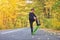 Kid skateboarder doing skateboard tricks in autumn environment