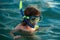 Kid snorkeling in ocean. Diving concept. Child dives into the water. Extreme sport. Kids summer holidays.