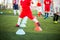 Kid soccer player Jogging and jump between red and blue cone markers on green artificial turf for soccer training