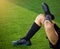 Kid soccer players is sitting with warming on green artificial turf for stretch muscles before and after play soccer game