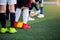 Kid soccer players standing with blurry cone marker on green artificial turf ready to training and start game